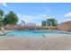 Relaxing community pool area with lounge chairs, set against a backdrop of clear blue skies and lush greenery at 4519 E Amberwood Dr, Phoenix, AZ 85048