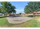 Well-maintained sand volleyball court surrounded by lush green grass and mature trees, perfect for outdoor recreation at 4519 E Amberwood Dr, Phoenix, AZ 85048