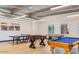 Well-lit recreation room with a pool table, ping pong table, and foosball, perfect for entertainment at 4741 E Fire Opal Ln, San Tan Valley, AZ 85143