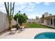 Backyard patio and seating area overlooking grassy lawn, desert landscaping, and perimeter wall at 4948 E Evans Dr, Scottsdale, AZ 85254