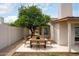 Backyard featuring a wooden dining table and chairs, a leafy green tree, and perimeter landscaping at 4948 E Evans Dr, Scottsdale, AZ 85254