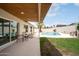 Backyard showcasing a covered patio, in-ground pool, a grassy lawn, and perimeter landscaping at 4948 E Evans Dr, Scottsdale, AZ 85254