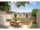 Backyard featuring outdoor dining table, grassy lawn, and perimeter landscaping at 4948 E Evans Dr, Scottsdale, AZ 85254