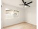 Bright, minimalist bedroom featuring a ceiling fan, light wood floors, and natural light at 4948 E Evans Dr, Scottsdale, AZ 85254
