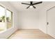 Bright, minimalist bedroom featuring a ceiling fan, light wood floors, and natural light at 4948 E Evans Dr, Scottsdale, AZ 85254