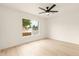 Bright, minimalist bedroom featuring a ceiling fan, light wood floors, and natural light at 4948 E Evans Dr, Scottsdale, AZ 85254