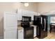 Bright kitchen features white cabinets, tile floors, black appliances, and granite countertops at 511 E Purdue Ave, Phoenix, AZ 85020