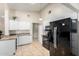 Bright eat-in kitchen features tile floors, white cabinets, modern black appliances and granite counters at 511 E Purdue Ave, Phoenix, AZ 85020