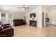Spacious living room featuring tile floors, a ceiling fan, a fireplace, and leather furniture at 511 E Purdue Ave, Phoenix, AZ 85020