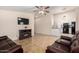 Open living room with tile flooring, ceiling fan, fireplace and leather furniture at 511 E Purdue Ave, Phoenix, AZ 85020