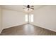 Bright bedroom features wood-look floors, ceiling fan, and lots of natural light from two windows at 53404 W Candlelight Rd, Maricopa, AZ 85139