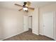 Cozy bedroom featuring wood-look floors, a ceiling fan, and two closets at 53404 W Candlelight Rd, Maricopa, AZ 85139