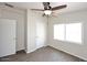 Bright bedroom featuring wood-look floors, a ceiling fan, and an ensuite bathroom at 53404 W Candlelight Rd, Maricopa, AZ 85139