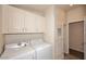 Functional laundry room with washer, dryer, and ample storage cabinets at 53404 W Candlelight Rd, Maricopa, AZ 85139