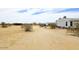 Desert property features a dirt road, native plants, and two single-story homes at 53404 W Candlelight Rd, Maricopa, AZ 85139