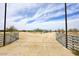 Gated entrance leading to a desert property under a blue sky with scattered clouds at 53404 W Candlelight Rd, Maricopa, AZ 85139