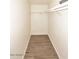 Bright walk-in closet featuring wood-look flooring and ample shelving at 53404 W Candlelight Rd, Maricopa, AZ 85139