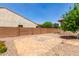 Backyard featuring block wall fencing, stone patio, and minimal landscaping at 5446 S Sandstone Ct, Gilbert, AZ 85298