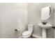 Neutral powder bath featuring white pedestal sink, oval mirror, and toilet at 5446 S Sandstone Ct, Gilbert, AZ 85298