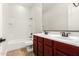 Bright bathroom featuring a double sink vanity, tile floors, and a white tiled shower-tub combination at 5446 S Sandstone Ct, Gilbert, AZ 85298