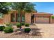 Charming exterior with a stone facade, neutral-colored garage door, and desert landscaping, providing curb appeal at 5446 S Sandstone Ct, Gilbert, AZ 85298
