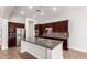 Modern kitchen with stainless steel appliances, dark wood cabinets, and a large center island with granite counters at 5446 S Sandstone Ct, Gilbert, AZ 85298