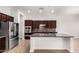 Modern kitchen with stainless steel appliances, dark wood cabinets, and a large center island at 5446 S Sandstone Ct, Gilbert, AZ 85298