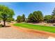 Scenic walking path featuring a lush green lawn and mature trees in a serene setting at 5446 S Sandstone Ct, Gilbert, AZ 85298