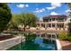 Waterfront backyard view, featuring a covered patio and lush greenery at 579 N Mondel Dr, Gilbert, AZ 85233