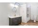 Bright bathroom featuring a gray vanity, gold faucet, and a combined shower and tub with white tile surround at 579 N Mondel Dr, Gilbert, AZ 85233