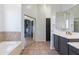 View of primary bathroom boasting soaking tub, double sinks, and mirrored closet at 579 N Mondel Dr, Gilbert, AZ 85233