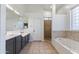 Primary bathroom boasts double sinks, soaking tub, glass-enclosed shower, and neutral-toned tiling at 579 N Mondel Dr, Gilbert, AZ 85233
