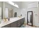 Bathroom featuring double sinks with modern fixtures, large mirror, and tiled shower at 579 N Mondel Dr, Gilbert, AZ 85233
