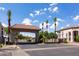 Grand entrance to a gated community with a terracotta-tiled roof, towering palm trees and well-maintained landscaping at 579 N Mondel Dr, Gilbert, AZ 85233
