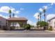 Elegant gated community entrance featuring a terracotta-tiled roof, black iron gates, and swaying palm trees at 579 N Mondel Dr, Gilbert, AZ 85233