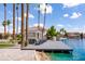 Scenic lake view featuring a private dock and patio furniture with luxurious homes in the background at 579 N Mondel Dr, Gilbert, AZ 85233