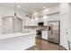 The bright kitchen features stainless steel appliances, white cabinetry, and a central island at 579 N Mondel Dr, Gilbert, AZ 85233