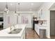 Bright kitchen features white cabinets, stainless steel appliances, quartz countertops, and eat-in dining space at 579 N Mondel Dr, Gilbert, AZ 85233
