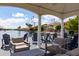 Outdoor patio furniture under a gazebo overlooking the tranquil lake with lush greenery and palm trees at 579 N Mondel Dr, Gilbert, AZ 85233