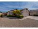 Charming single-story home featuring a well-manicured lawn, flowering trees, and a two-car garage at 5924 W Shangri La Rd, Glendale, AZ 85304