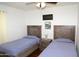 Cozy bedroom featuring two twin beds, rustic wood furniture, and a ceiling fan at 6920 E Beverly Ln, Scottsdale, AZ 85254