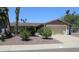 Single-story home with a two-car garage, desert landscaping, and palm trees at 6920 E Beverly Ln, Scottsdale, AZ 85254