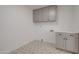 Clean laundry room featuring gray cabinetry, patterned flooring, and essential hookups at 743 N Bermuda --, Mesa, AZ 85205