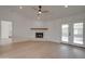 Bright living room featuring wood floors, a white brick fireplace, a ceiling fan and french doors at 743 N Bermuda --, Mesa, AZ 85205