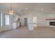 Bright living room and kitchen area featuring neutral walls and floors, modern lighting, and white cabinets at 743 N Bermuda --, Mesa, AZ 85205