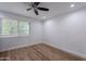 Bright bedroom featuring hardwood floors, a ceiling fan, and a large window for natural light at 7800 E Lincoln Dr # 2029, Scottsdale, AZ 85250