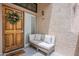 Charming entrance featuring a cozy sitting area and a beautifully decorated wooden door with a wreath at 7800 E Lincoln Dr # 2029, Scottsdale, AZ 85250