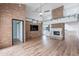 Inviting open-concept living area with brick accents, fireplace, wood floors, and views to the modern kitchen space at 7800 E Lincoln Dr # 2029, Scottsdale, AZ 85250