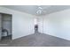 Bright bedroom features neutral carpet, white walls, ceiling fan, and a closet with an open white door at 8924 N 102Nd Ln, Peoria, AZ 85345