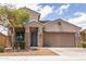 Charming two-story home featuring a well-manicured lawn, tree, and an attached two-car garage at 8924 N 102Nd Ln, Peoria, AZ 85345